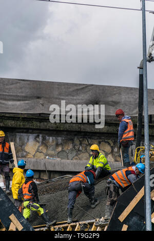 Krakow, Poland - September 24, 2018: Construction workers working on a tunnel construction site, with concrete truck on the street Stock Photo