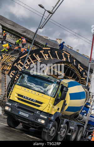 Krakow, Poland - September 24, 2018: Construction workers working on a tunnel construction site, with concrete truck on the street Stock Photo