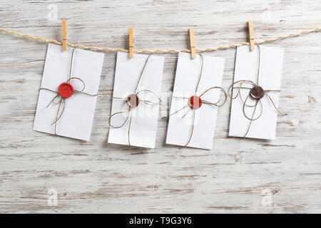 White envelopes hanging on rope Stock Photo