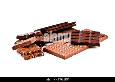 Heap of broken dark and milk chocolate bars with hazelnuts isolated on white background. Stock Photo