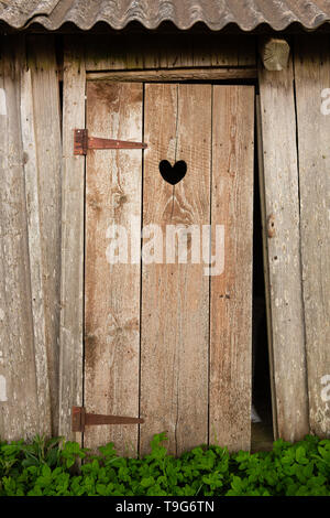 Wooden doors with heart shaped hole in it Stock Photo