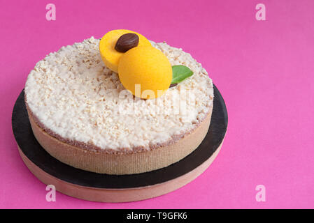 Coconut tart with apricot and white chocolate on pink background Stock Photo