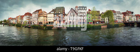 Spring panorama of Strasbourg city in front of Quai des Bateliers street along water canal. Fachwerk timber framing colorful houses. Traditional archi