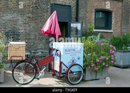 Ruby Violet Ice Cream bicycle with red sunshade next to planters in front of shop Kings Cross London England Britain UK Stock Photo