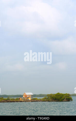 Small home on island in lagoon near Placencia, Belize Stock Photo