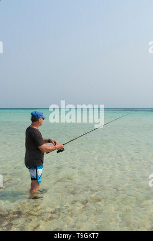 Man fishing off the shore of  Ranguana Caye, Belize Stock Photo