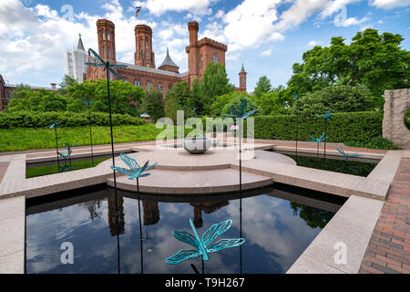 Washington, DC - May 9, 2019: The Moongate Garden with dragonfly statues in the Enid Haupt Garden and the Smithsonian Castle on the National Mall Stock Photo