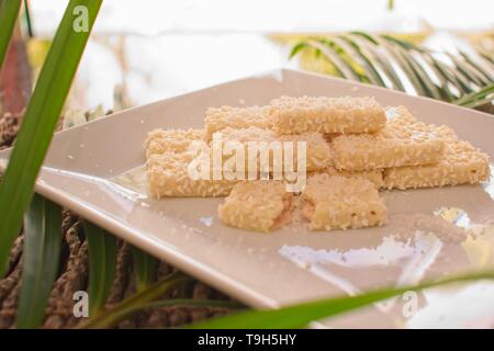 White chocolate biscuit with coconut on a plate, a delicious summer snack. Stock Photo