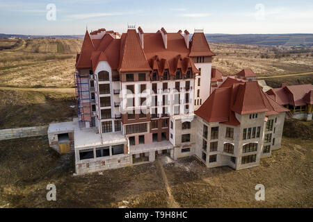 Aerial view of unfinished multistoried residence, hotel or cottage building with stucco wall, cast iron balcony railings, steep shingle roof and shiny Stock Photo