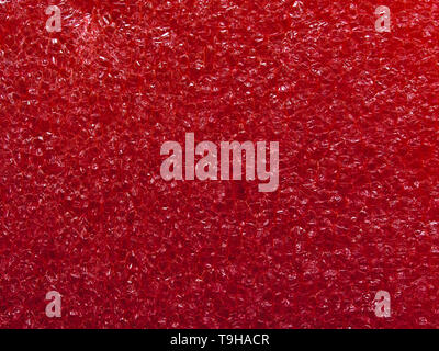 Red porous surface close up macro image. Textured background. Stock Photo
