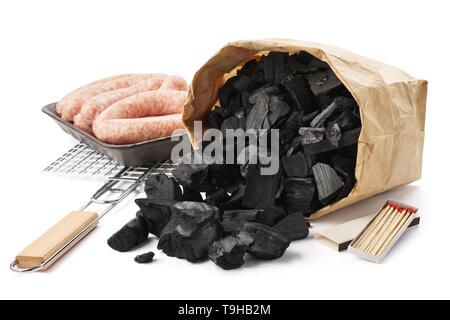 Set of tools and ingredients for barbecue. Paper bag of charcoal, grill, sausages and matches. Isolated. Stock Photo