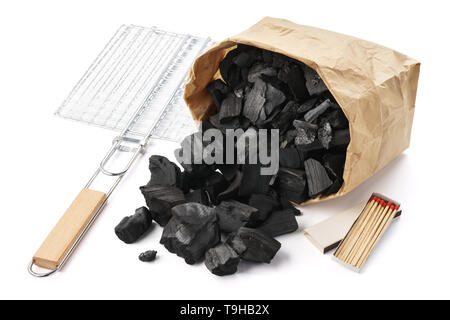 Set of tools and ingredients for barbecue. Paper bag of charcoal, grill and matches. Isolated. Stock Photo