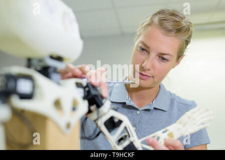 young female technician while machine constructing in a manufacturing plant Stock Photo