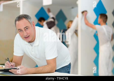 portrait of painting and decorating teacher class working in background Stock Photo
