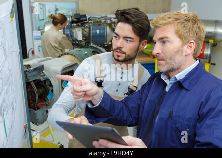 workers analyzing construction plans Stock Photo