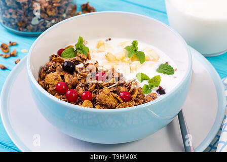 Breakfast. Bowl of homemade granola with yogurt and fresh berries. Table setting. Healthy food. Stock Photo