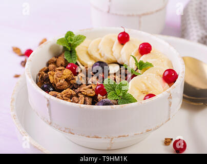 Breakfast. Bowl of homemade granola with yogurt and fresh berries. Table setting. Healthy food. Stock Photo
