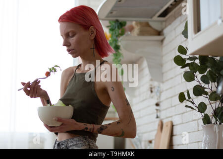 Skinny anorexic woman having no appetite looking at salad Stock Photo