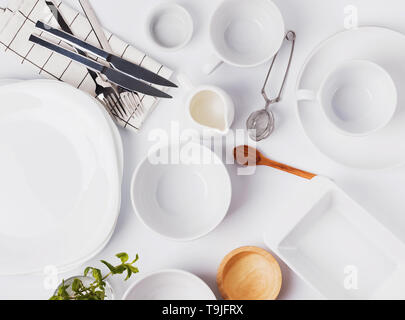 Different tableware and dishes on the white background, top view. Kitchen accessories flat lay. Stock Photo