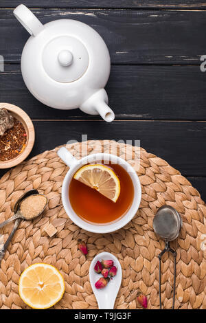 Cup of tea, teapot and different accessories and ingredients for tea preparation, top view Stock Photo