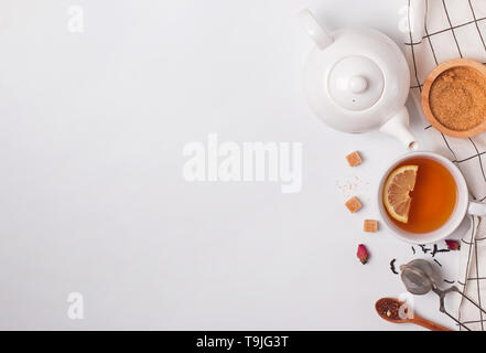 Tea time creative composition. Cup, teapot and sugar on the white background, top view Stock Photo
