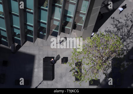 Looking down from an aerial view towards small business figures walking through sunlight in the City of London, the capital's ancient financial district, on 13th May, in London, England. Stock Photo