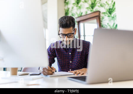 Handsome young business man with working place in creative office Stock Photo
