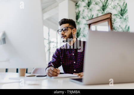 Handsome young business man with working place in creative office Stock Photo