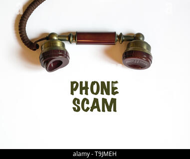 Phone call that is a scam. An antique telephone receiver with the text phone scam printed below it. Stock Photo