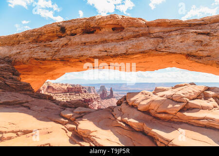 Classic view of famous Mesa Arch, symbol of the American West, illuminated in scenic golden morning light at sunrise on a beautiful day in summer Stock Photo