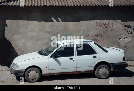 Bakhchysarai, Republic of Crimea - April 1, 2019: White sedan car Ford Sierra parked near the building Форд Сиера Крым Россия Бахчисарай Сутинер Stock Photo