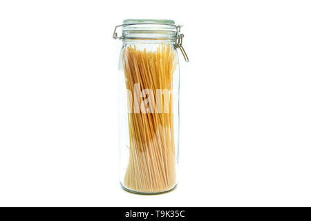 The spaghetti pasta stored inside the closable glass bottle isolated on a white background. Stock Photo