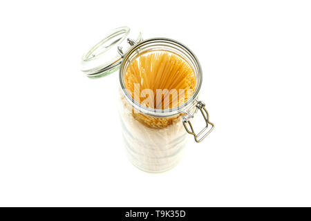 The spaghetti pasta stored inside the closable glass bottle isolated on a white background. Stock Photo