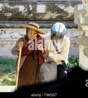 Bagan, Myanmar - Feb 9, 2017. Old woman coming to the pagoda in Bagan, Myanmar. Bagan in central Burma is one of the world greatest archeological site Stock Photo