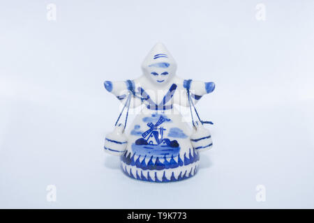 Delft Blue Figurine of girl carrying bells. Souvenir from Holland/Netherlands on isolated white background. Stock Photo