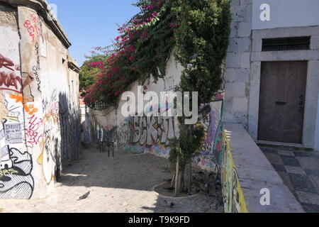 A narrow street with graffiti in the old part of Lisbon Stock Photo