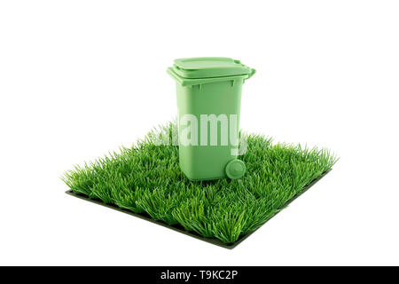 Green recycle bin on square of green grass field isolated on white background Stock Photo