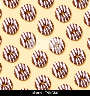 Chocolate donuts pattern on yellow background Stock Photo