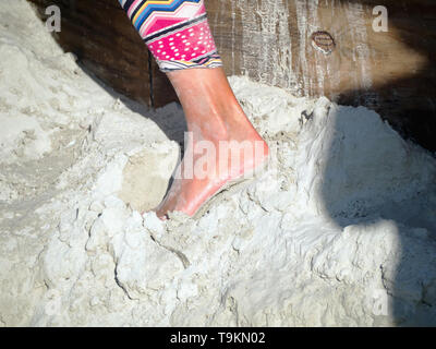 Morgan Rudluff plants a foot in the sand while working at the 2019 Texas Sandfest in Port Aransas, Texas USA. Stock Photo