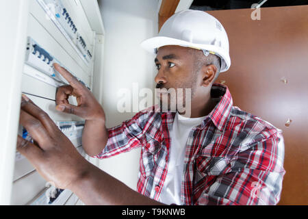 electrician installing energy saving meter Stock Photo