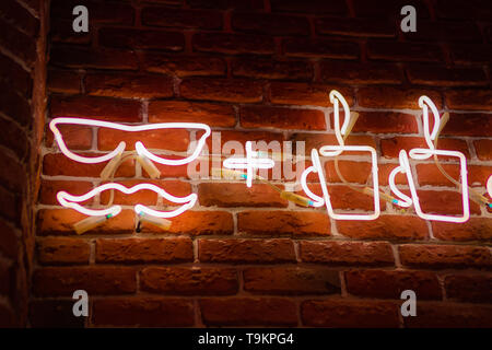 Neon sign with cups of coffee on the background of a red brick wall. Abstract hipster background. Stock Photo
