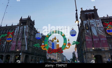 Christmas lights and decorations with Gobierno de Mexico banners of historical figures, Plaza de la Constitucion, Zocalo, Mexico City. Stock Photo