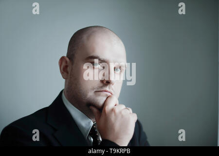 close up. portrait of a thoughtful businessman on a gray background. Stock Photo