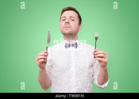 Hungry man holding fork and knife on hand to eat Stock Photo