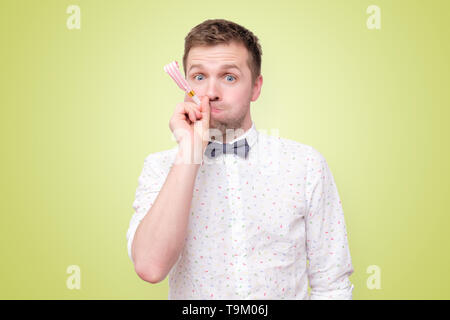 Man having fun on party wearing blowing party horn. Stock Photo