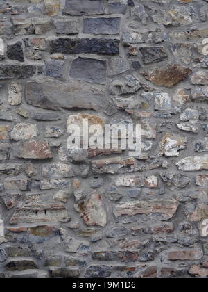 Old limestone wall, showing grey, white and brown in the stone Stock Photo