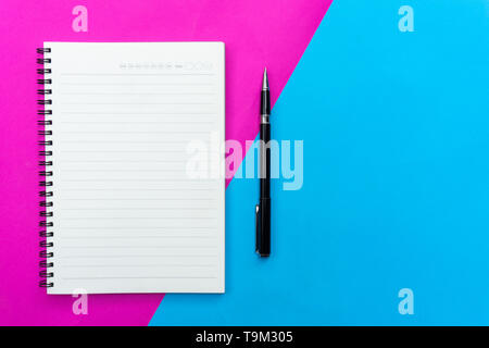 Top view blank notebook and black pen for mockup flat lay on blue and pink background. Stock Photo
