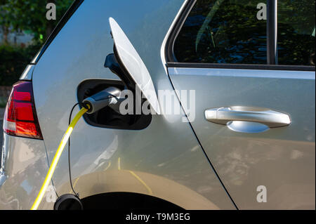 silver colored electric car charging on a roadside charger in Berlin/Germany Stock Photo
