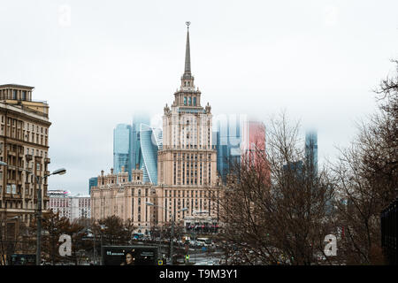 Hotel Ukraina, the second largest of the seven sisters (neoclassical Stalin-era), in front of Moskva City skyscrapers covered in fog (Moscow, Russia) Stock Photo