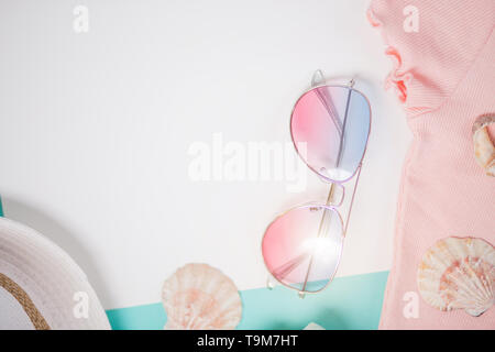 Summer accessories and holiday concept, composition from womans clothes, sunglasses, straw hat, seashells on white background with copy space. Top vie Stock Photo